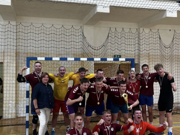 Uczniowie wraz z trenerami pozujący do zdjęcia na hali sportowej