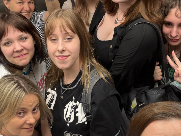 Grupa młodzieży jedzie windą z opiekunami
