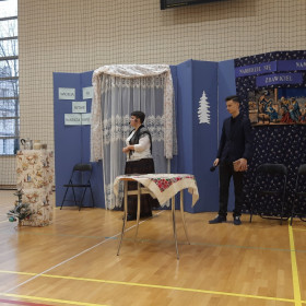 Na scenie dziewczyna i chłopak z prezentem w ręce.