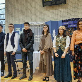 Koniec spektaklu, na scenie dziewięć osób stoi w rzędzie.
