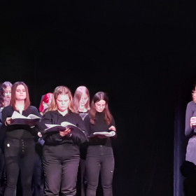 Na scenie teatru młodzież czyta Antygonę. Kreon i Tyrezjasz z przodu.