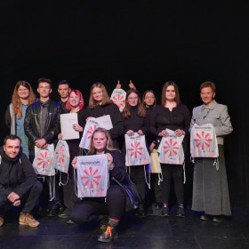 Na scenie teatru wszyscy uczestnicy warsztatów stoją do zdjęcia grupowego.