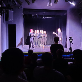 W teatrze zdjęcie z widowni młodzieży na scenie.