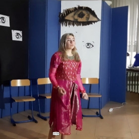 Główna bohaterka stoi na scenie i wygłasza monolog