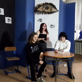 Uczniowie siedzą przy stole i rozmawiają