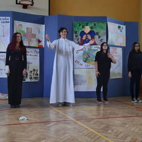 Uczniowie stoją na środku grając pantomimę.