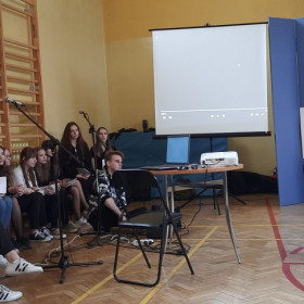 Zespół muzyczny siedzi na ławkach.