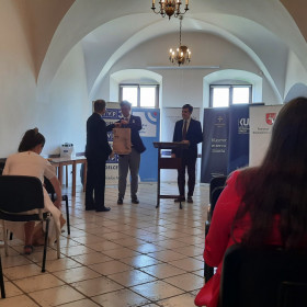 Organizatorzy wręczają nagrody osobie z komisji.
