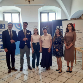 W sali obrad stoją nasze uczennice wraz z organizatorami.