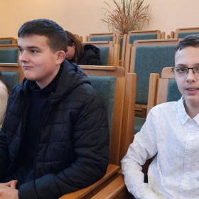 Dwóch uczniów z naszej szkoły siedzi na auli przed konkursem.