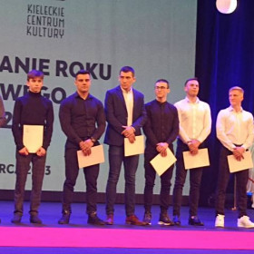 Osiem osób stoi na wspólnym zdjęciu podczas Gali Podsumowania Roku Sportowego 2022.
