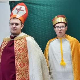 W sali lekcyjnej stoja biskup Jordan i Mieszko I