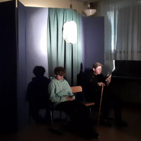 Główny bohater Albert siedzi na scenie obok starszego pana.