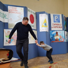 Mężczyzna ciągnie za rękę małego chłopca.