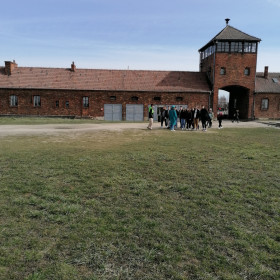 Młodzież przy bramie obozu Birkenau.
