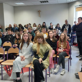 Młodzież z różnych klas siedzi na widowni
