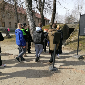 Uczniowie stoją przed wejściem do komory gazowej.