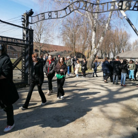 Uczniowie wchodzą przez brame na teren obozu koncentracyjnego.