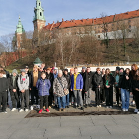 Zdjęcie grupowe uczniów na tle Wzgórza Wawelskiego.