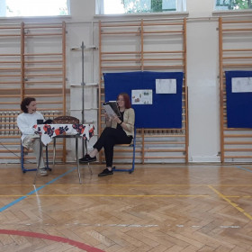 Prowadzący i dziewczyna dialogują przy stole