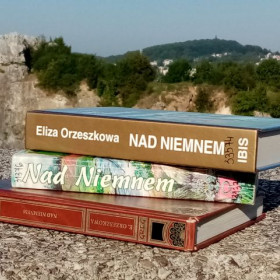Trzy książki Nad Niemnem leżą na tle skał