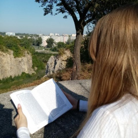 Uczennica czyta książkę Nad Niemnem na Kadzielni