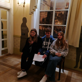Uczniowie siedzą na ławce w muzeum