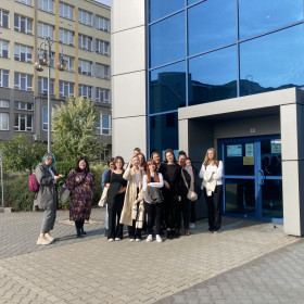 Wolontariusze stoją na tle budynku Politechniki Świętokrzyskiej