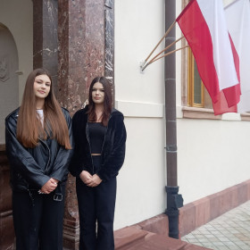 Uczennice stoją przed drzwiami do Sanktuarium Marszałka Józefa Piłsudskiego 