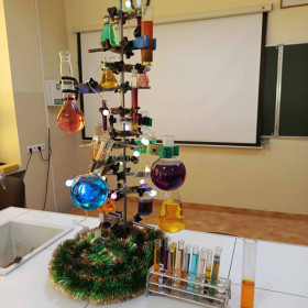 Choinka wykonana ze statywu i różnych naczyń laboratoryjnych z kolorowymi roztworami