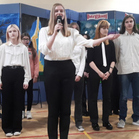 Dziewczyna z grupa osób składa wszystkim życzenia 