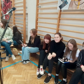 Osoby w scholi przygotowują się do śpiewu