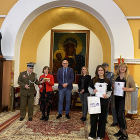 Grupa osób w tle obraz Matki Bożej