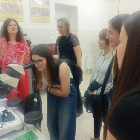 Uczennica obserwuje preparaty materiałów biologicznych przez mikroskop