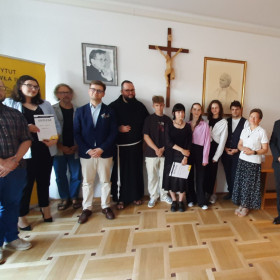 Finaliści konkursu wraz z komisją na tle portretu Jana Pawła II