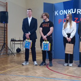 Stoją nagrodzeni uczniowie z panią dyrektor