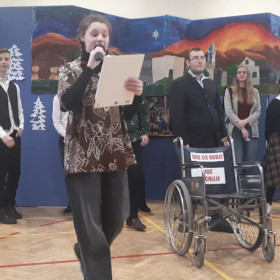 Dziewczyna czyta wiersz z życzeniami w tle uczniowie