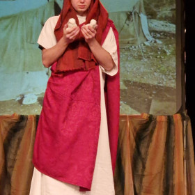 Abraham na scenie trzyma posążki dwóch synów