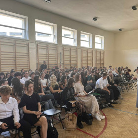 Uczniowie siedzą na sali i odpowiadają na pytania