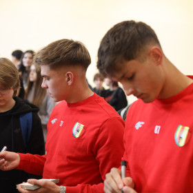 uczniowie przyjmują kartki z autografami