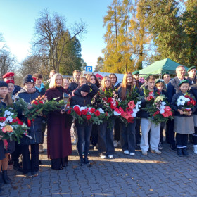 Marszałek Województwa wraz z uczniami przed wejściem na cmentarz