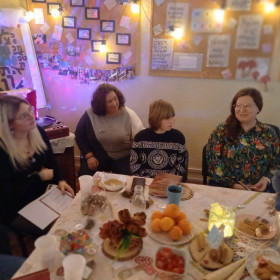 cztery osoby siedzą przy stole