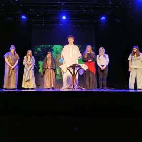 bohaterowie spektaklu wokół stołu na scenie