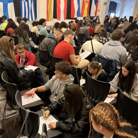 na zdjęciu widać dużą grupę ludzi pracującą przy projekcie edukacyjnym