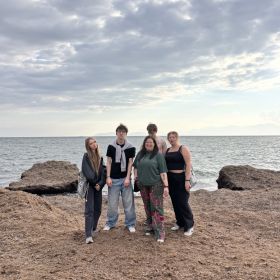 na zdjęciu widać uczniów wraz z nauczycielką na tle morza