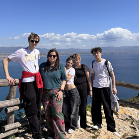 na zdjęciu widać uczniów wraz z nauczycielką na tle morza