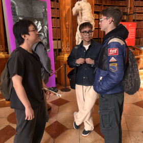 Na zdjęciu widoczna jest biblioteka narodowa w Wiedniu na pierwszym planie 3 osoby rozmawiają