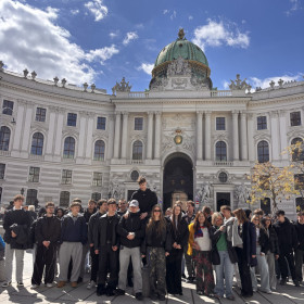 Na zdjęciu widoczna jest zabytkowa katedra na pierwszym planie stoją uczniowie wraz z nauczycielami