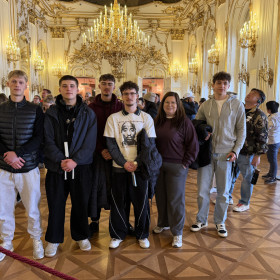 Na zdjęciu widoczne jest wnętrze pałacu na pierwszym planie stoi grupa uczniów