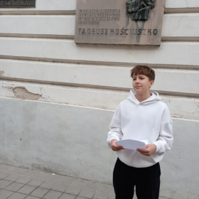Uczeń przed tablicą pamiątkową